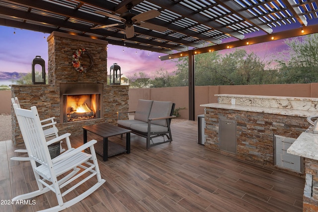 deck at dusk featuring an outdoor living space with a fireplace