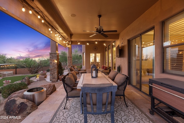 patio terrace at dusk featuring outdoor lounge area and ceiling fan