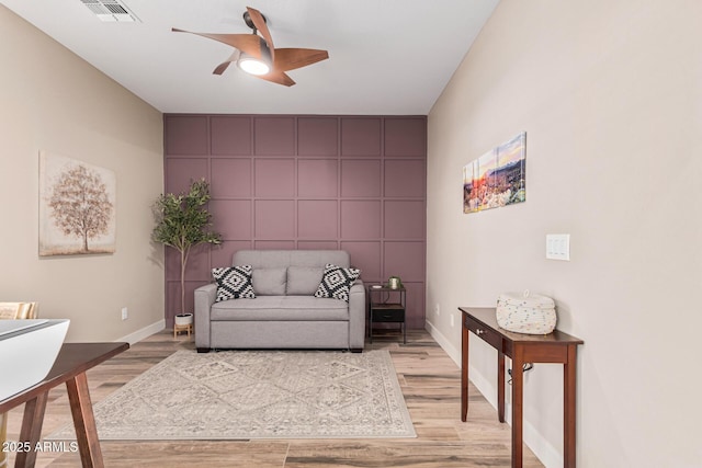 living area with ceiling fan and light wood-type flooring