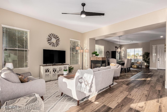 living room with hardwood / wood-style flooring and ceiling fan with notable chandelier