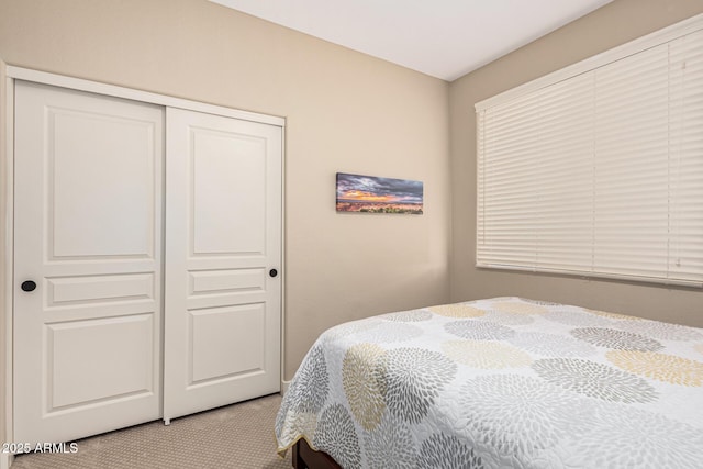 bedroom featuring light colored carpet and a closet