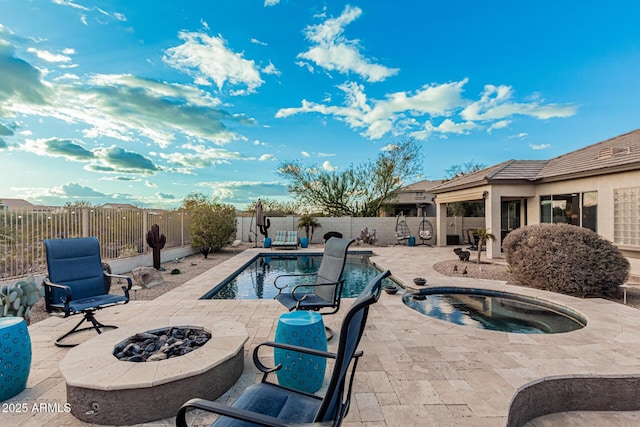 view of swimming pool featuring an in ground hot tub, a patio, and an outdoor fire pit