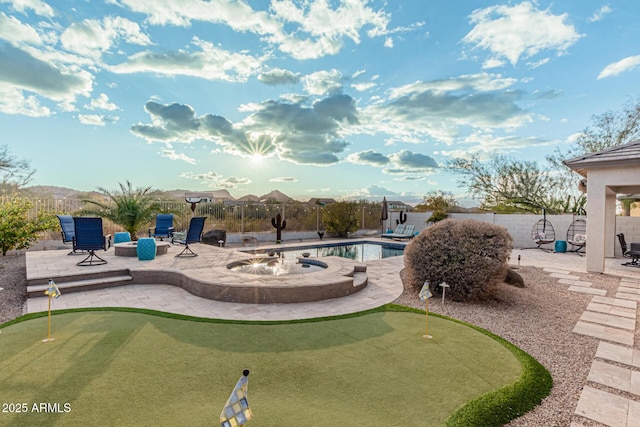 view of swimming pool with a mountain view, a fire pit, and a patio area