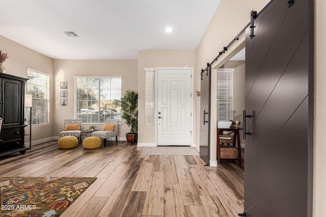 entrance foyer with a barn door and light wood-type flooring