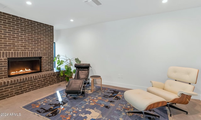 sitting room featuring brick wall and a brick fireplace