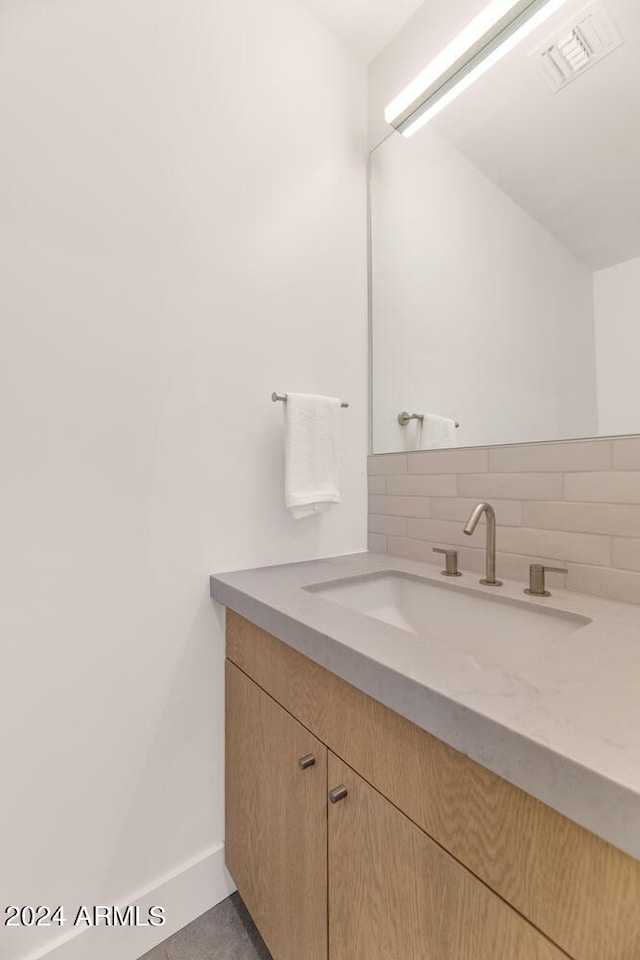 bathroom with decorative backsplash and vanity