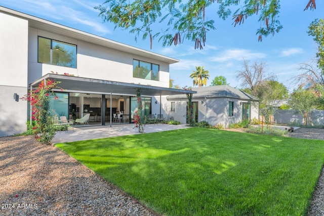 back of property featuring a lawn and a patio area