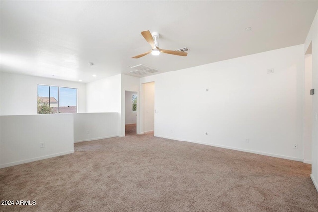 unfurnished room with light colored carpet and ceiling fan