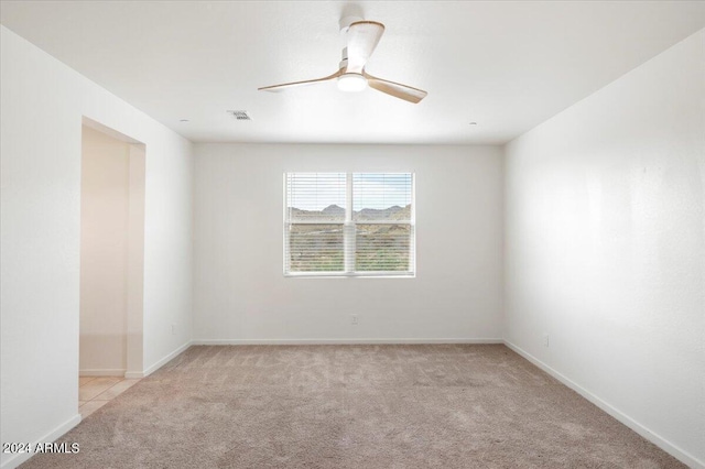 carpeted spare room featuring ceiling fan