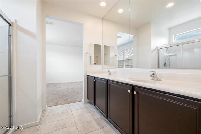 bathroom with double sink vanity, walk in shower, and tile patterned flooring