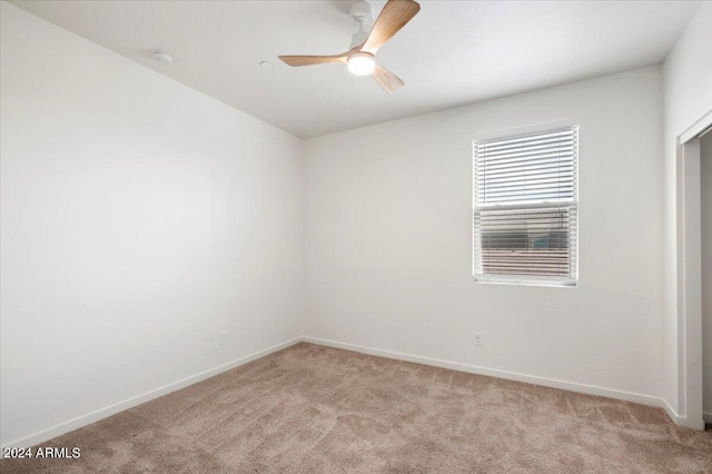 spare room featuring light colored carpet and ceiling fan