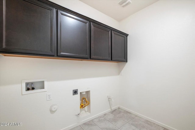 laundry room with hookup for an electric dryer, light tile patterned floors, hookup for a washing machine, cabinets, and hookup for a gas dryer