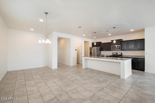 kitchen with light tile patterned flooring, stainless steel appliances, a center island with sink, and pendant lighting