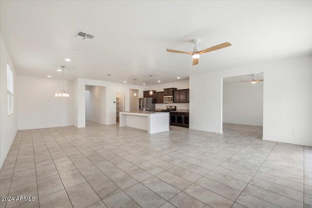 unfurnished living room featuring ceiling fan with notable chandelier and light tile patterned floors