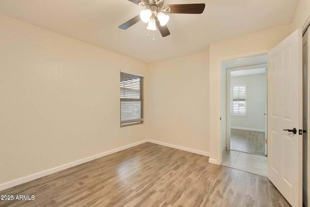 empty room with ceiling fan and light hardwood / wood-style floors