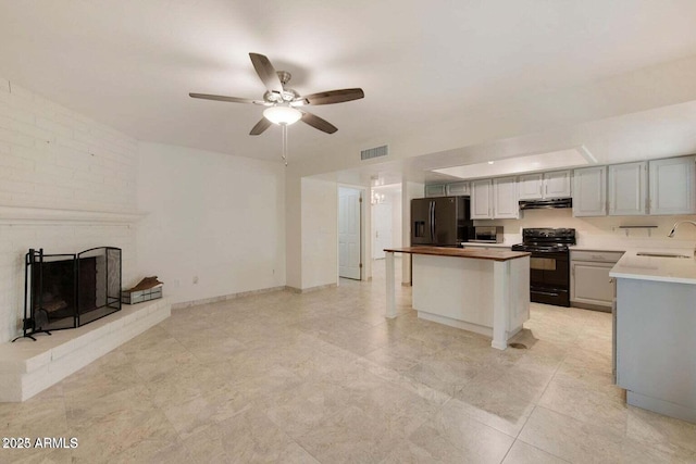 kitchen featuring a fireplace, sink, refrigerator with ice dispenser, ceiling fan, and black range with electric cooktop