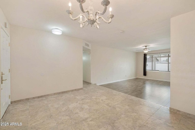 empty room with ceiling fan with notable chandelier