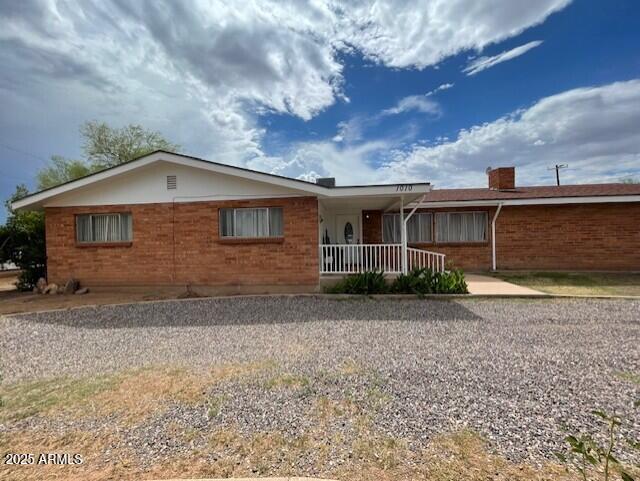 1010 N Florida Ave, Douglas, AZ 85607 - ranch-style home featuring covered porch, brick siding, and a chimney
