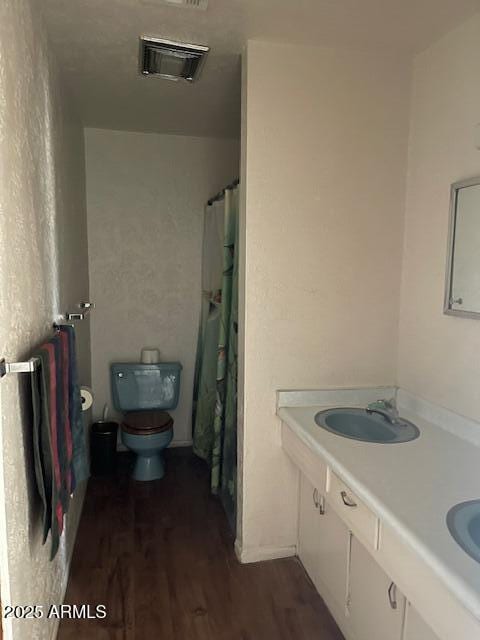 1010 N Florida Ave, Douglas, AZ 85607 - full bathroom featuring toilet, wood finished floors, and double vanity
