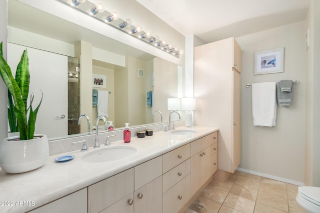 bathroom with toilet, tile patterned floors, and vanity