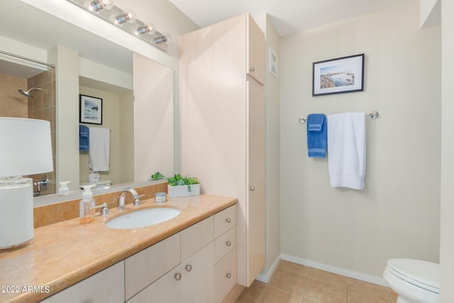 bathroom with toilet, tile patterned floors, and vanity