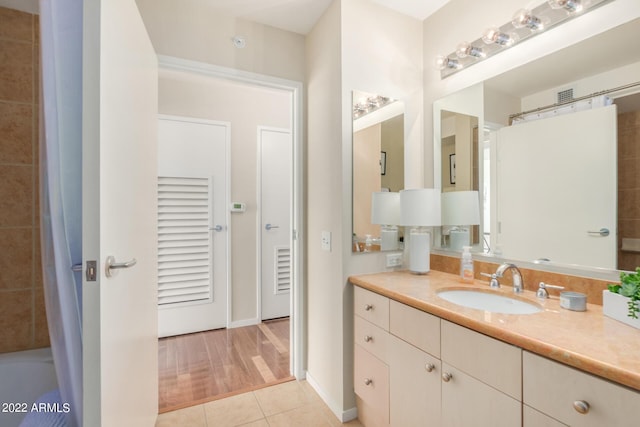 bathroom with walk in shower, vanity, and tile patterned flooring