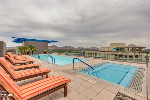 view of swimming pool with a mountain view, a hot tub, and a patio