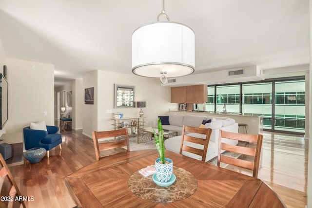 dining space featuring wood-type flooring and sink