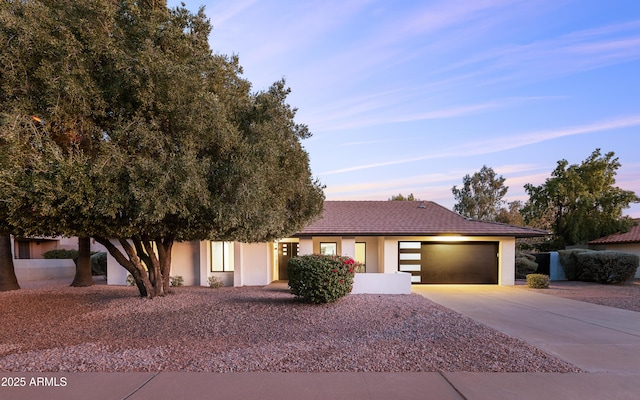 view of front of property featuring concrete driveway, a garage, and stucco siding