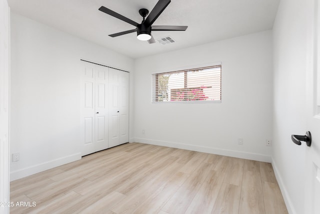 unfurnished bedroom featuring wood finished floors, a closet, baseboards, and ceiling fan