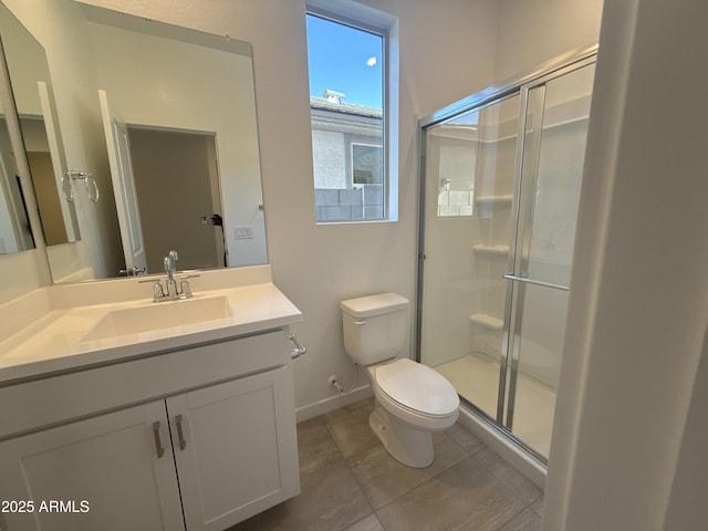 bathroom featuring toilet, a shower stall, baseboards, and vanity