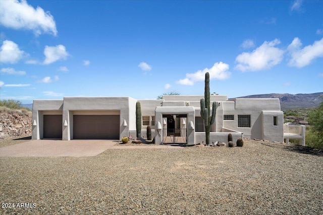 adobe home featuring a garage and a mountain view