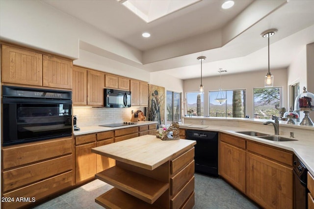 kitchen with butcher block countertops, sink, black appliances, hanging light fixtures, and backsplash