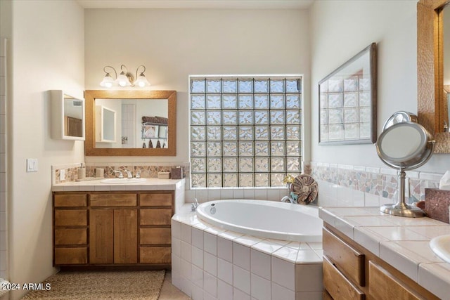 bathroom featuring vanity and tiled bath