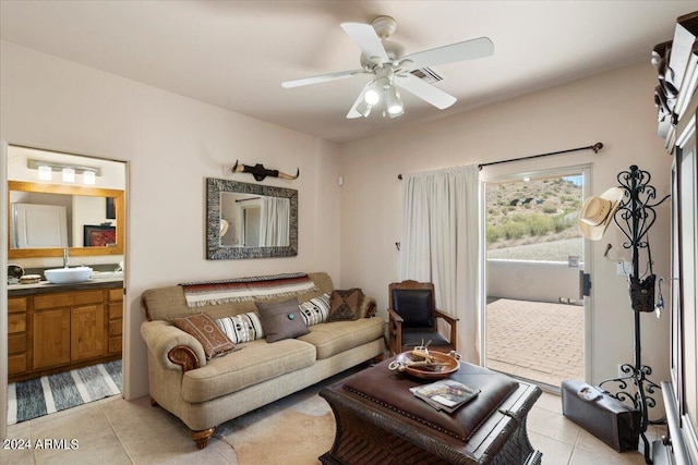 living room with ceiling fan, sink, and light tile patterned floors