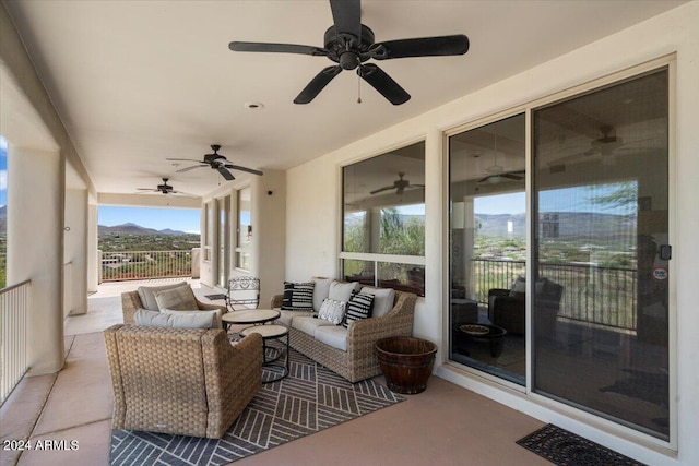 view of patio / terrace with an outdoor living space, a mountain view, and ceiling fan