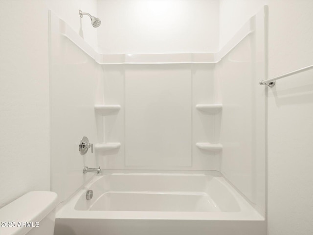 bathroom featuring shower / bathing tub combination and toilet