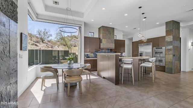1805 E Rocky Slope Dr, Phoenix, AZ 85048 - kitchen with a spacious island, wall chimney range hood, hanging light fixtures, stainless steel appliances, and modern cabinets