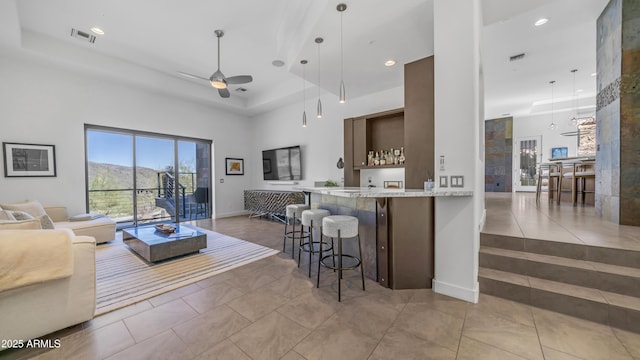 1805 E Rocky Slope Dr, Phoenix, AZ 85048 - tiled living room with a ceiling fan, visible vents, baseboards, a tray ceiling, and a towering ceiling