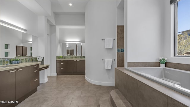 1805 E Rocky Slope Dr, Phoenix, AZ 85048 - bathroom with tile patterned floors, baseboards, two vanities, a bath, and a sink