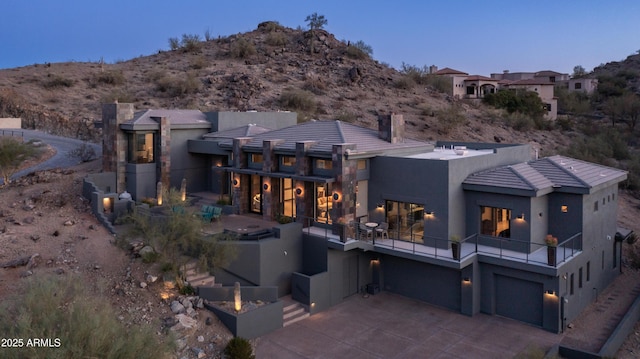 1805 E Rocky Slope Dr, Phoenix, AZ 85048 - back of property featuring stucco siding, concrete driveway, an attached garage, a balcony, and a chimney