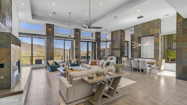 1805 E Rocky Slope Dr, Phoenix, AZ 85048 - tiled living area featuring a fireplace, a high ceiling, a ceiling fan, and visible vents