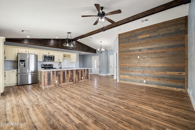 kitchen with dark hardwood / wood-style floors, pendant lighting, cream cabinetry, decorative backsplash, and appliances with stainless steel finishes