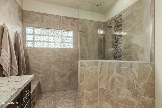 bathroom featuring a tile shower and vanity