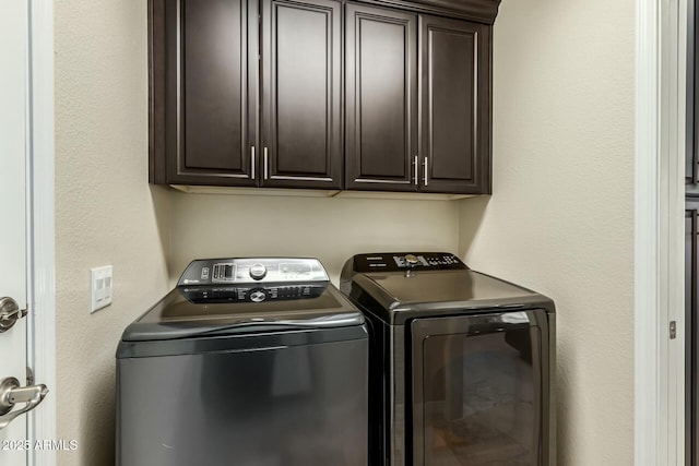 clothes washing area featuring cabinets and independent washer and dryer