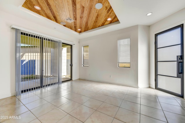 unfurnished room with light tile patterned floors, wood ceiling, and a tray ceiling