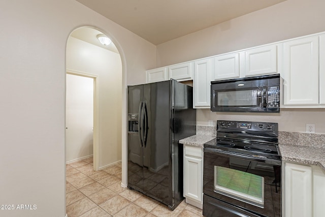 kitchen with light stone countertops, black appliances, and white cabinets