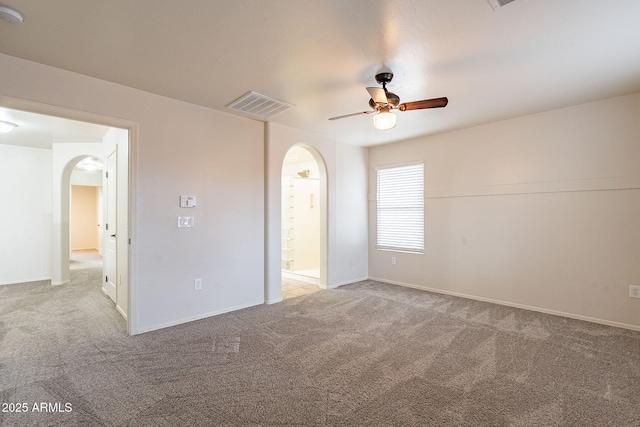 unfurnished bedroom featuring connected bathroom, light colored carpet, and ceiling fan