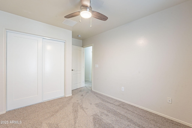 unfurnished bedroom with light colored carpet, ceiling fan, and a closet