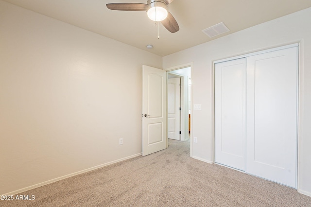 unfurnished bedroom featuring light colored carpet, ceiling fan, and a closet